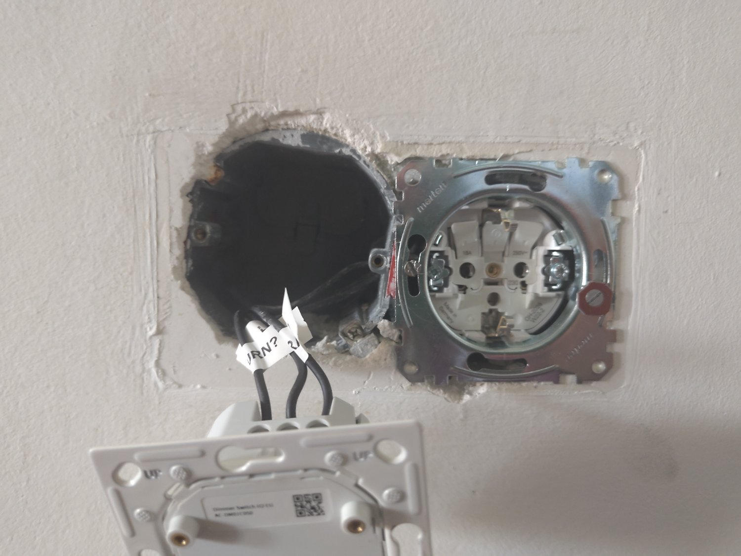 Photo of a light switch assembly hanging out of the wall in front of a very tilted electrical box.