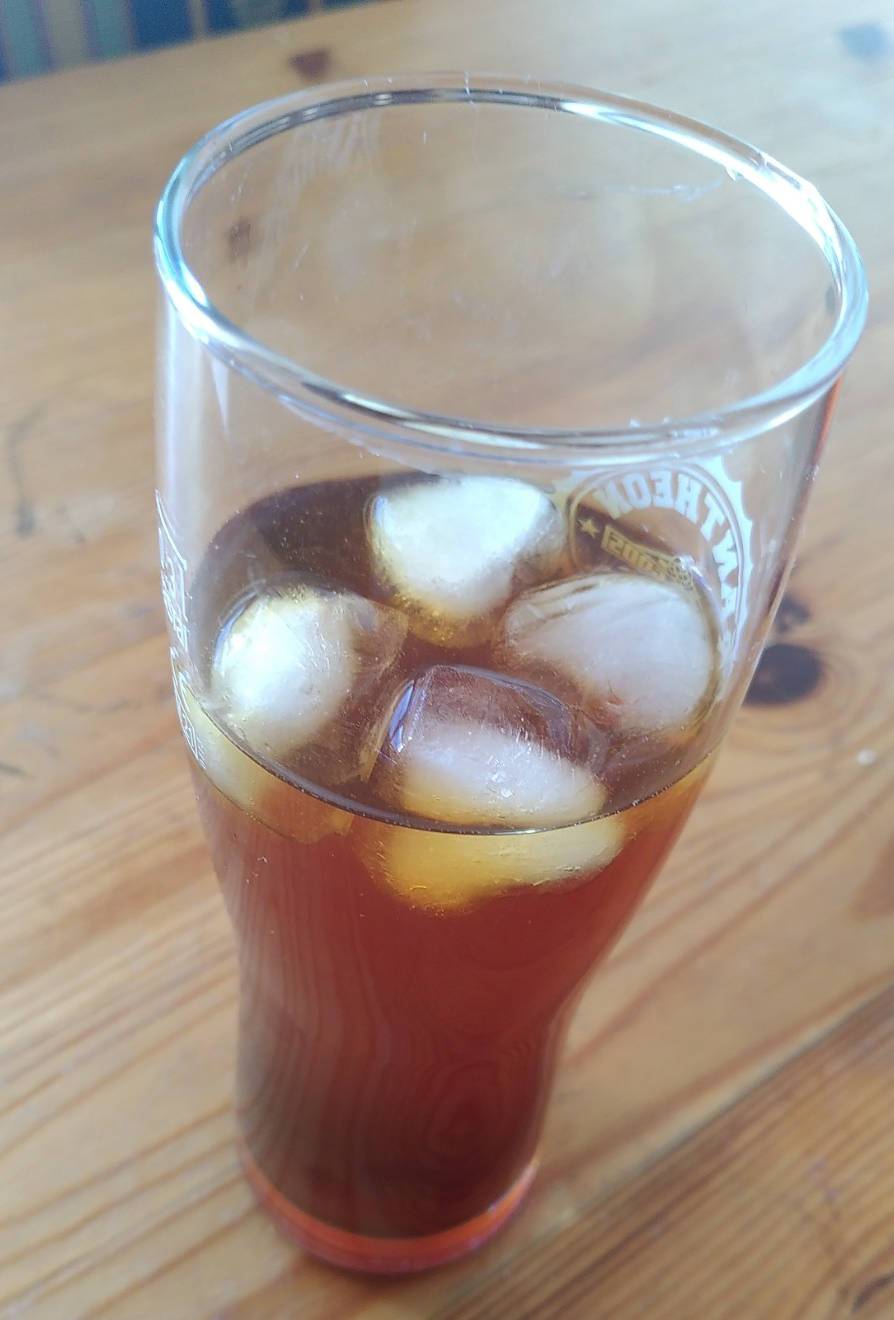 Ein Glas mit Kaffee und Eiswürfeln gefüllt.