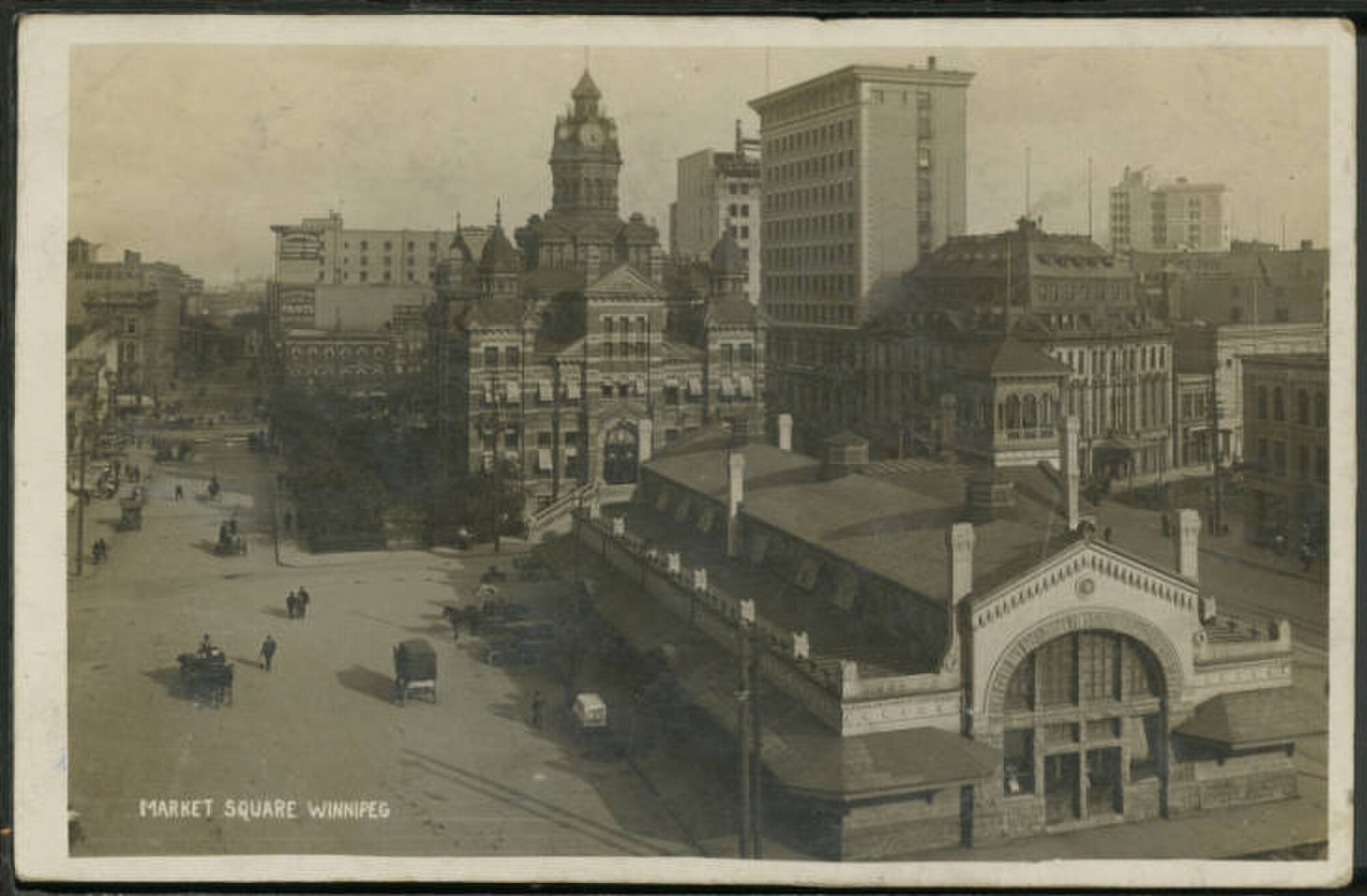 Market Square in Winnipeg, Manitoba c. 1912. Old City Hall (rear), the Union Bank Tower and the Leland Hotel in background You can also see the Confederation Building (under construction, above centre). Postcard from the Martin Berman Postcard Collection at the Winnipeg Public Libraries. Originally published by Lyall Commercial Photo Co., Limited. Anonymous, from Wikimedia Commons