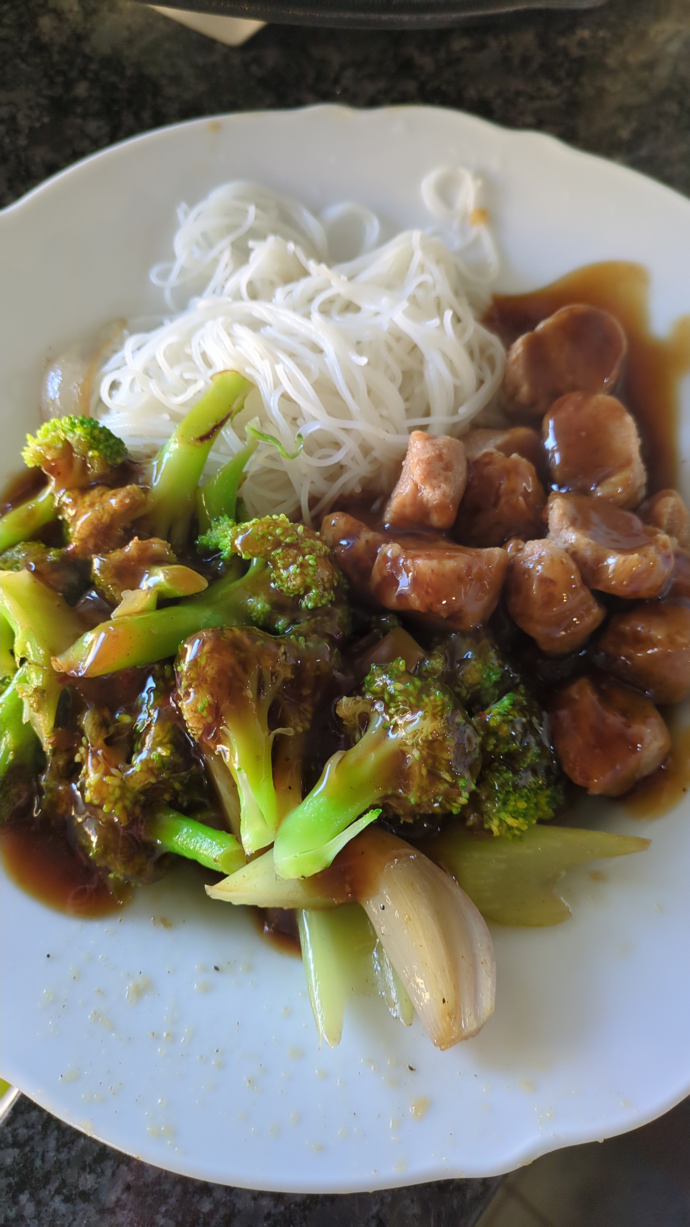 Broccoli, rice vermicelli and soya beef nuggets on a plate