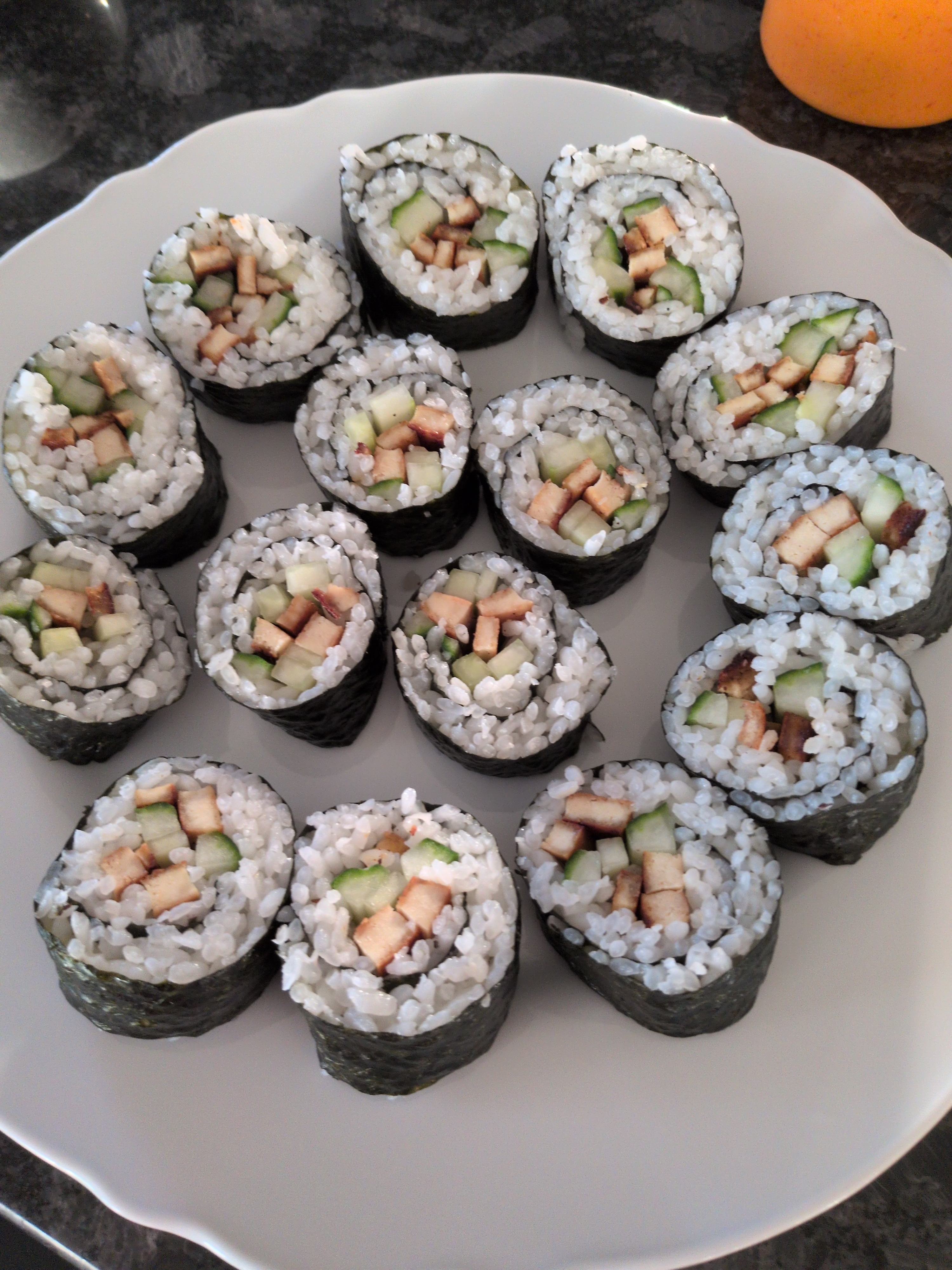 plates of sushi rolls with cucumber and tofu