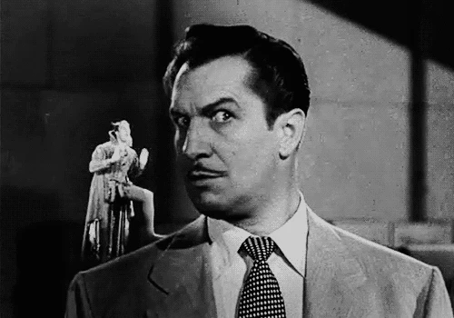 Vincent Price smiling as he watches the devil on his shoulder mime pushing someone off a cliff