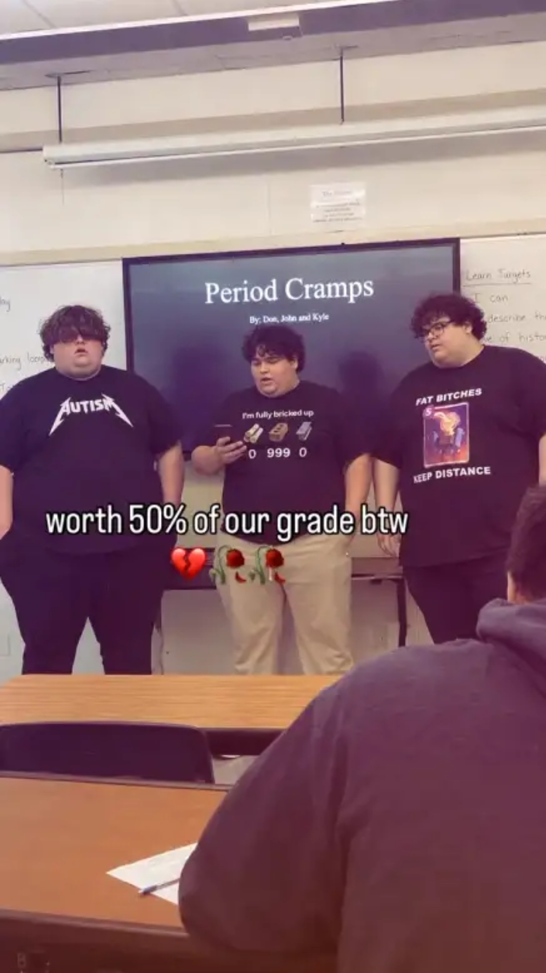 Three overweight boys are holding a presentation on period cramps. All of them have silly T-shirts on: one reads "Autism" in the style of the Metallica logo, the other says "I'm fully bricked up", with a picture of a a video game inventory full of bricks, the third says "Fat bitches keep distance". The caption to the photo reads "worth 50% of our grade btw".