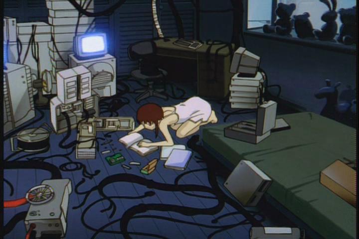 Screenshot of the anime "Serial Experiments Lain" showing the main character surrounded by stacks of cyberpunky parts and equipment she's assembling into an insane homemade computer.