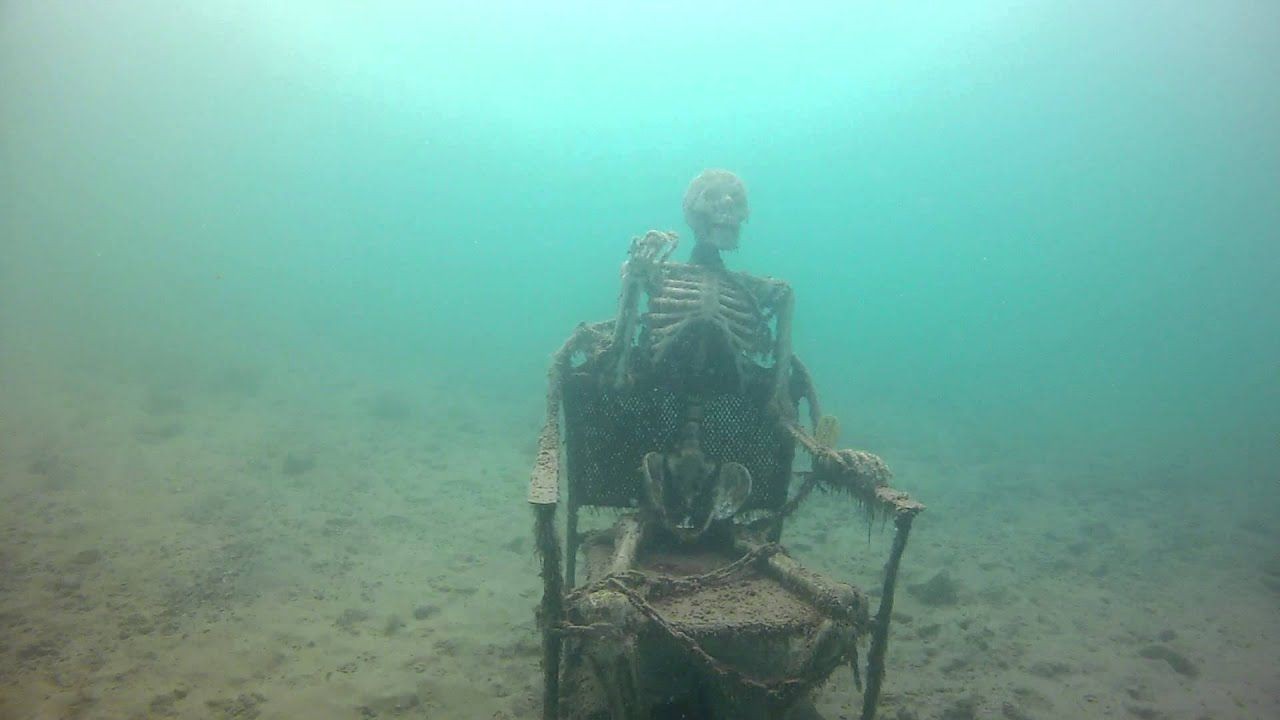 Picture of an old skeleton sitting on a chair underwater