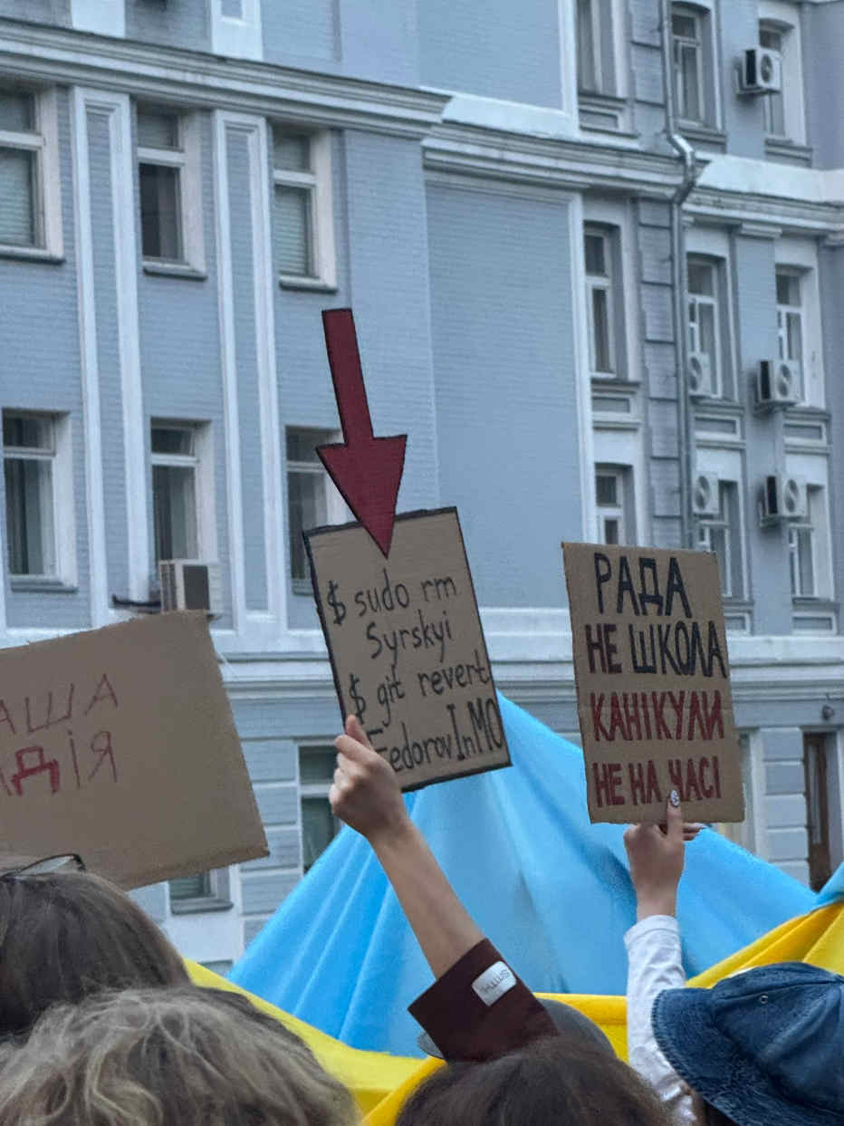 A protest sign reads "sudo rm Syrskyi; git revert FedorovInMO"