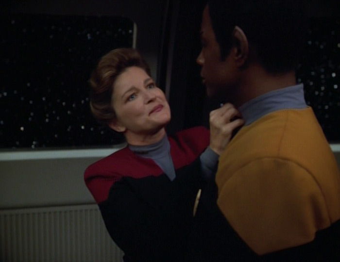 Janeway smiles admirably at Tuvok while applying an additional pip to his collar, Star Trek: Voyager S4E5 "Revulsion"