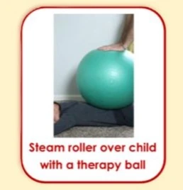 Image of a child lying on their back on the floor, with a persons hand from outside the image boundaries pushing a large yoga ball onto the kid. The kids head is cut off from the image, but they seem happy