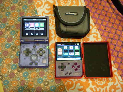 Two gaming handhelds. Left on in clear blue, right one in clear purple.